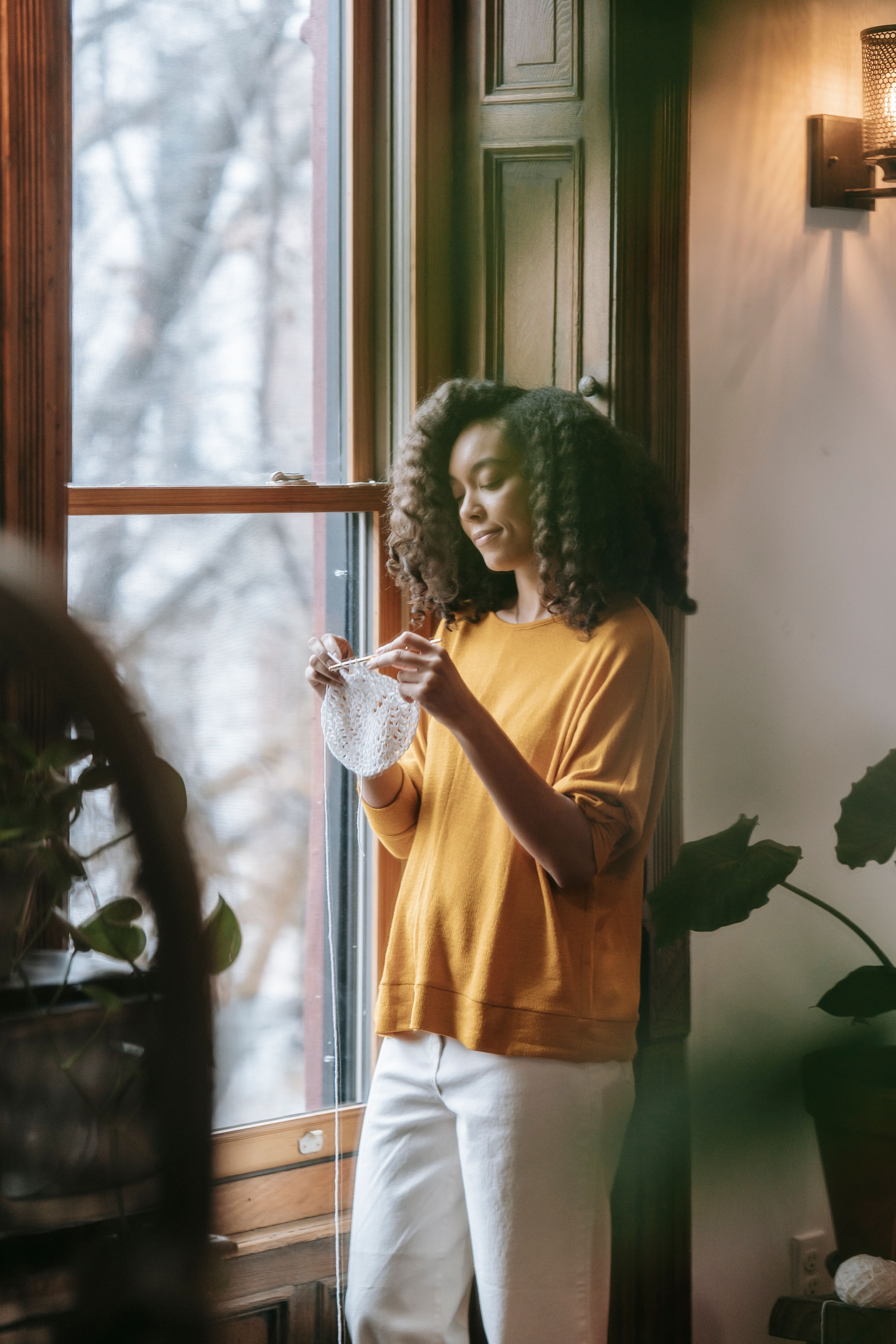 Woman pausing by a sunlit window, a quiet moment
